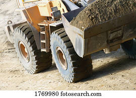 Close up of a tractor carrying dirt
