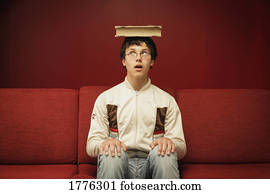 Teenager balancing a book on his head