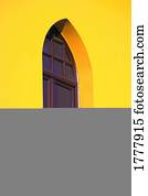 A window in a bright yellow wall