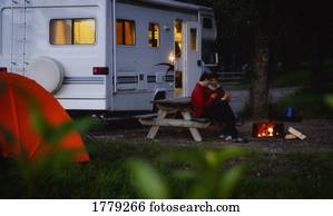 Couple sitting by campfire