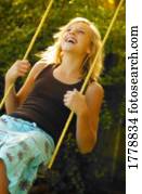 Teenager swinging on swing