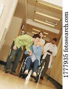 Two young adults visiting a senior woman in the hospital