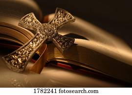 Gold cross on open bible