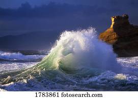 Wave crashing, distant storm, rock cliffs of Cape Kiwanda