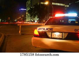 A police car on duty during the night. A police car on duty during the night.