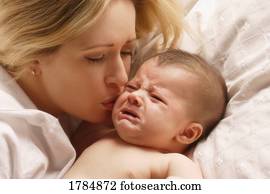 Young mother kissing crying baby