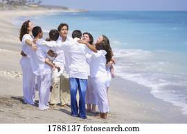 A group of people pray together at the beach A group of people pray together at the beach