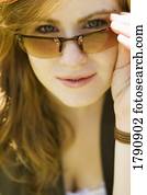 Woman looking over sunglasses