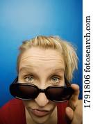Woman wearing sunglasses with humorous facial expression