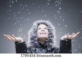 Woman with open hands to falling snow
