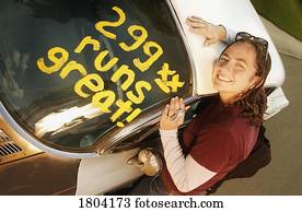 High angle view of a girl leaning over car
