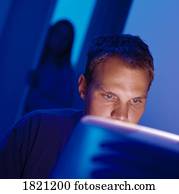 Man working at computer with woman watching him