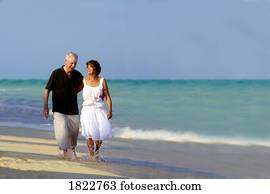 A senior couple walking along the beach