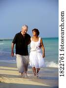 A senior couple walking along the beach