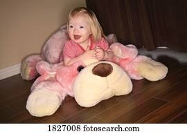 Girl sitting on stuffed animal