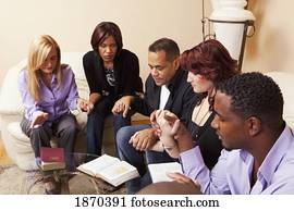a group of adults praying together with their bibles open