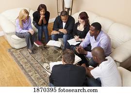 a group of adults praying with their bibles open a group of adults praying with their bibles open