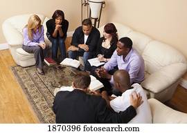 a group of adults praying with their bibles open a group of adults praying with their bibles open