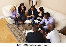 a group of adults praying with their bibles open a group of adults praying with their bibles open