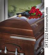 a gun, bullets and bouquet of roses on top of a coffin