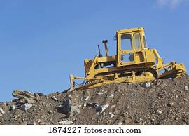a bulldozer parked amongst rubble to be cleared