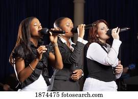 fort lauderdale, florida, united states of america; three women singing into microphones