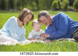 parents sitting on the grass with their young son