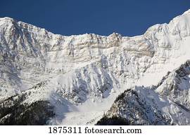 alberta, canada; snow covered mountain ridge and cliff in kananaskis country