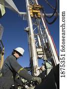 edson, alberta, canada; drilling rig worker working on the control panel on rig platform