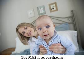 mother holding up baby