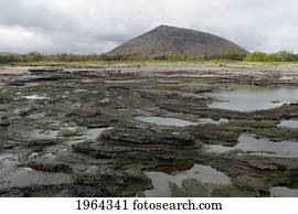 a landscape with molten rock and shallow water; santiago island, galapagos, equador