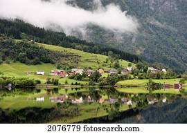 Houses in a valley along the water with low cloud; granvin norway