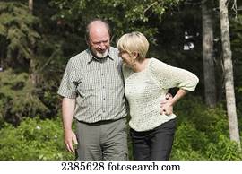 A senior couple walking and talking together in a park; Stony Plain, Alberta, Canada