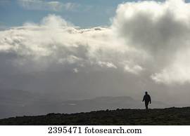A man walks out of the clouds from the summit of Maol Chean-dearg; Torridon, Scotland