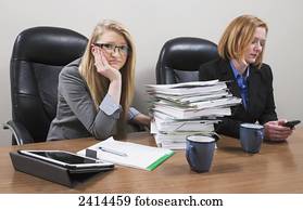 An accounting intern looking overwhelmed by a pile of paperwork; Edmonton, Alberta, Canada