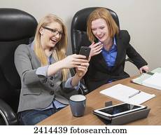 Co-workers laughing about a social media message; Edmonton, Alberta, Canada