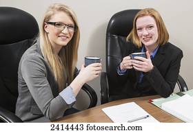 Co-workers relaxing over a coffee during a work day; Edmonton, Alberta, Canada