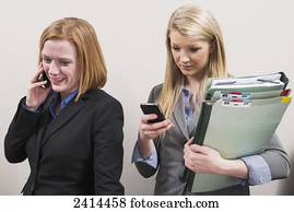 Co-workers wasting time talking and texting; Edmonton, Alberta, Canada