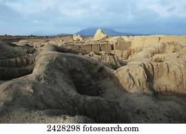 Extreme rugged terrain under a cloudy sky; Chan Chan, Peru