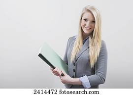 Portrait of a young businesswoman doing filing at an office; Edmonton, Alberta, Canada