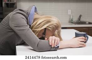 Young office worker asleep in the coffee room; Edmonton, Alberta, Canada