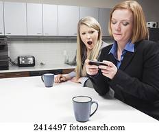 Young office worker shocked at messages on co-worker's smart phone; Edmonton, Alberta, Canada