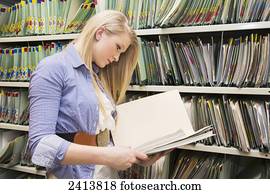 Young woman filing documents at an accounting office; Edmonton, Alberta, Canada