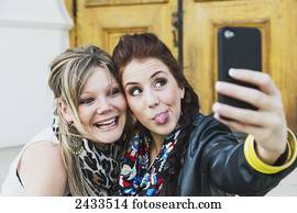 Two friends taking a self-portrait with a cell phone; Edmonton, Alberta, Canada