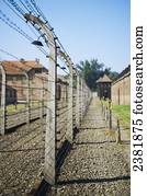 Barbed wire fences with cell blocks and guard tower in Auschwitz concentration camp; Osweciem, Poland