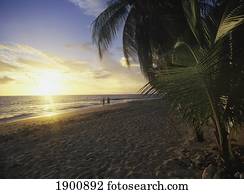 Couple Walking Along Beach At Dusk Couple Walking Along Beach At Dusk