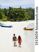 Couple Walking Hand-In-Hand Along Beach Couple Walking Hand-In-Hand Along Beach