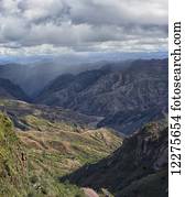 The colourful mountainous landscape of Toro Toro National Park, with a rainstorm in the distance; Bolivia