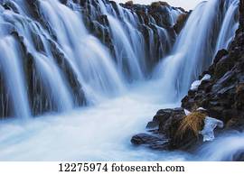Waterfalls flowing over rugged rock cliffs; Bruarfoss, Iceland