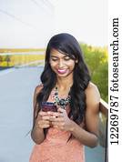 Young professional businesswoman texting on her smart phone; Edmonton, Alberta, Canada